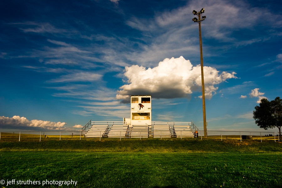A stadium with bleachers and a cloudy sky
