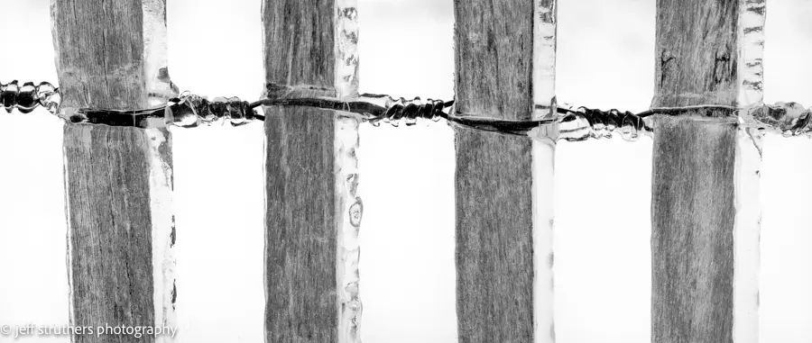 A close up of the fence with barbed wire