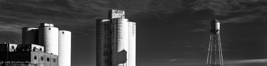 A black and white photo of three silos.