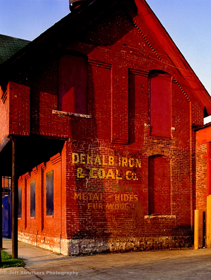 A red brick building with an advertisement on the side.
