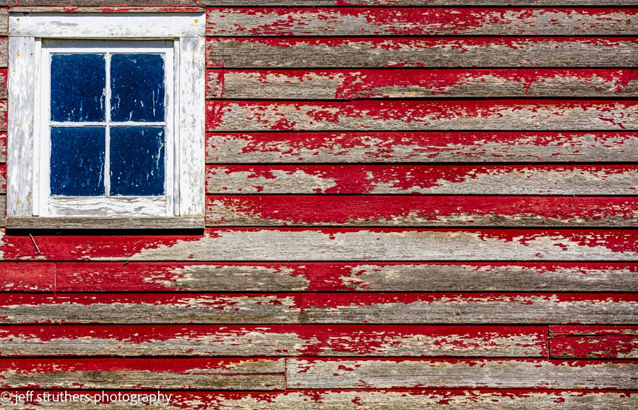 A red and white striped building with peeling paint.
